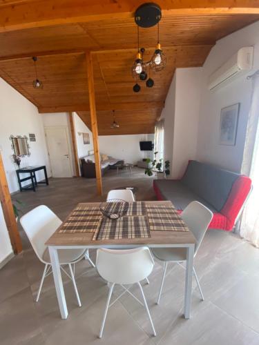 a table and chairs in a living room with a couch at Blue View in Kavala