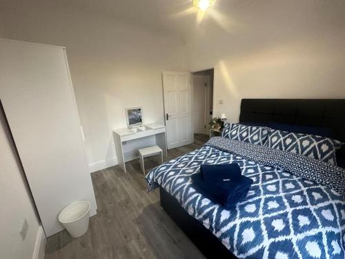 a bedroom with a bed with a blue pillow on it at Modern 2 bedroom flat, SE6 in Catford