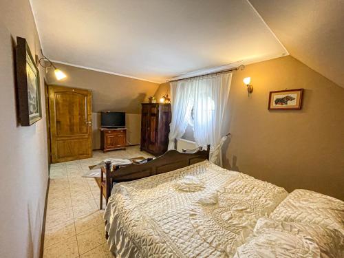 - une chambre avec un lit et une télévision dans l'établissement Pensjonat Stajnia Cesarska, à Kadyny