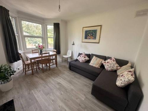 a living room with a couch and a table at Modern 2 bedroom flat, SE6 in Catford