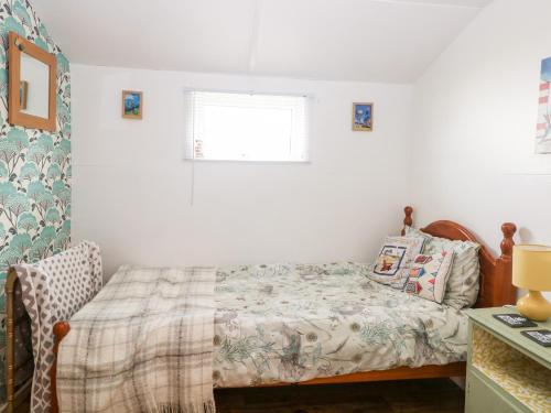 a small bedroom with a bed and a window at Suzanne's Beach Hut in Norwich