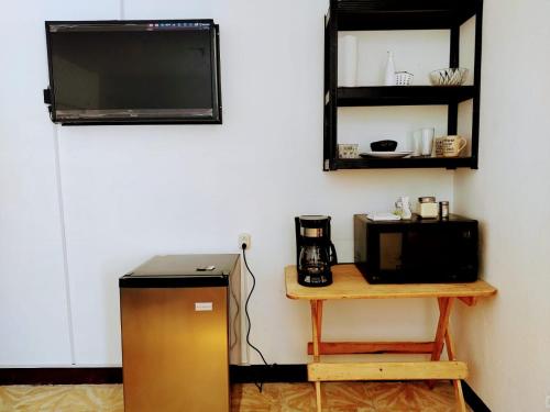 eine Küche mit einem Kühlschrank und einem Tisch mit einer Mikrowelle in der Unterkunft Villas Cairo in Guatemala