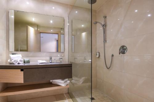 a bathroom with a shower and a sink and a mirror at TH Lazise - Hotel Parchi Del Garda in Lazise