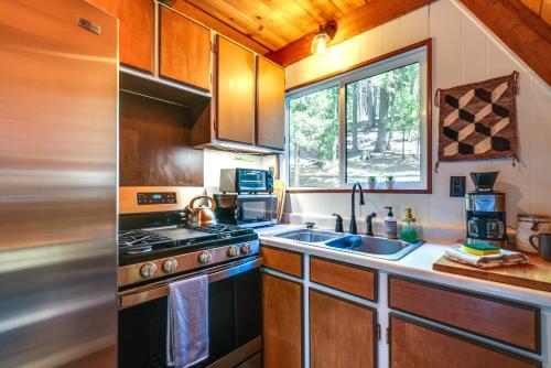 a kitchen with a stove and a sink and a window at Decks, Grills and Fire Pit Camp Connell Hideaway! in Camp Connell
