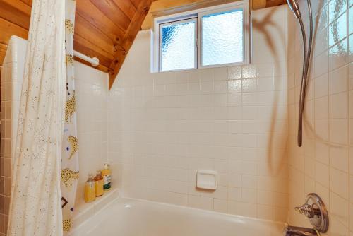 a bathroom with a white tub and a window at Decks, Grills and Fire Pit Camp Connell Hideaway! in Camp Connell