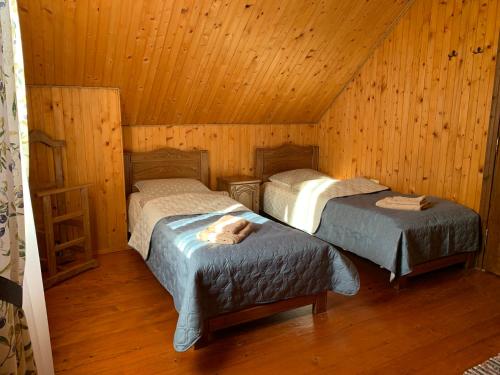 una camera con 2 letti in una cabina di legno di Dereviy a Jaremče