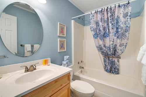 een badkamer met een wastafel, een toilet en een spiegel bij Coastal Murrells Inlet Condo with Balcony! in Myrtle Beach