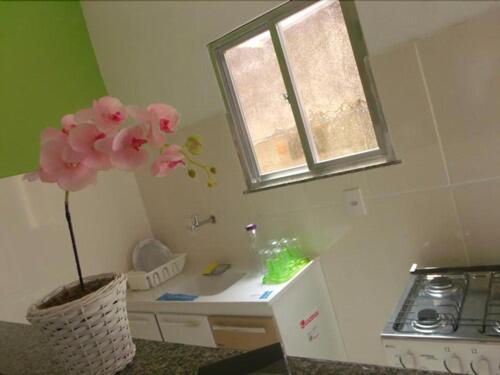 a kitchen with a vase with a flower in it at Pousada Flor de Liz in Angra dos Reis