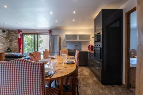 Il comprend une cuisine et une salle à manger avec une table en bois. dans l'établissement Chalet le Chardon Bleu, à Villarembert