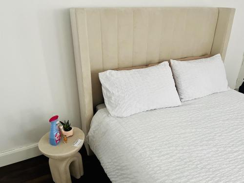 Newly refurbished 1-Bed Apartment in Croydon SE25 في لندن: غرفة نوم بسرير ابيض وطاولة صغيرة
