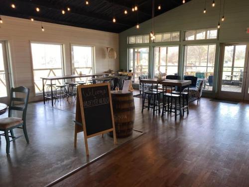 a large room with tables and chairs and a bar at Hive Check - Safari Tent - BeeWeaver Honey Farm in Navasota