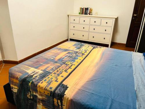 1 cama en un dormitorio con tocador y colcha en Casa Maria, en Galluzzo