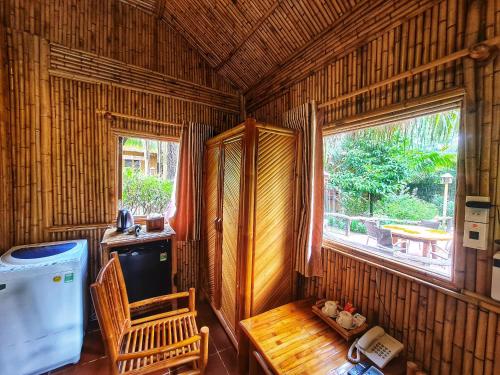 a room with a table and a chair and a window at Bamboo Eco Village in Can Tho