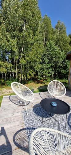 two chairs and a table on a patio with trees at Ostoja Będzyn- Wypoczynek nad Pilicą in Piotrków Trybunalski