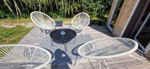 four white chairs and a table on a patio at Ostoja Będzyn- Wypoczynek nad Pilicą in Piotrków Trybunalski