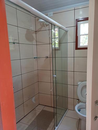 a bathroom with a glass shower with a toilet at Casa do Éden in Paraty