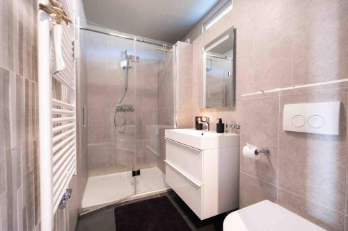 een badkamer met een douche, een toilet en een wastafel bij Hello Noordwijk - Appartement Duindamseweg 14E in Noordwijk