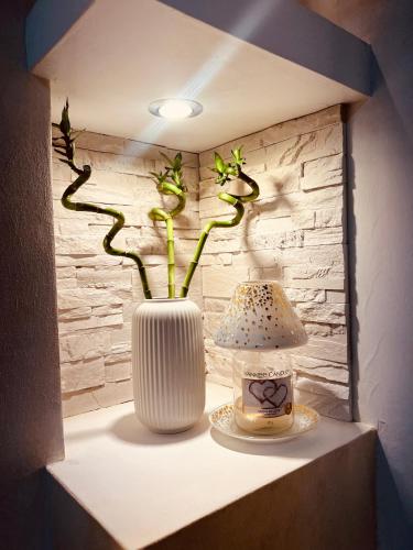 a white vase sitting on a shelf with a lamp at Serendipity in Bentivoglio