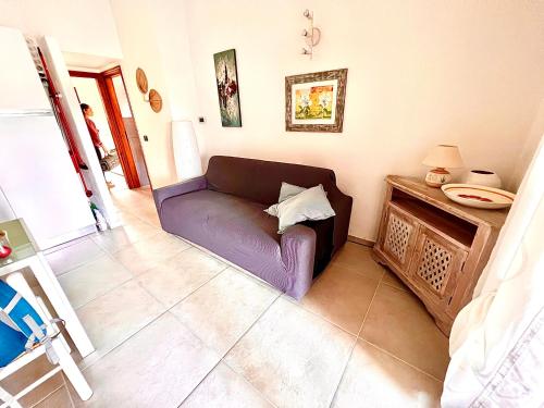 una sala de estar con un sofá púrpura en una habitación en Villetta la Cinta, en San Teodoro