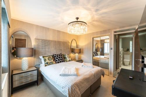 a bedroom with a large bed and a chandelier at 33 Dunbar Court Gleneagles Village in Auchterarder