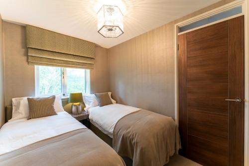two beds in a small room with a window at 33 Dunbar Court Gleneagles Village in Auchterarder