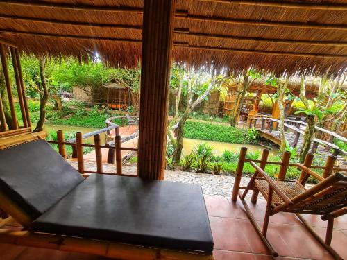 a screened in porch with a table and two chairs at Bamboo Eco Village in Can Tho