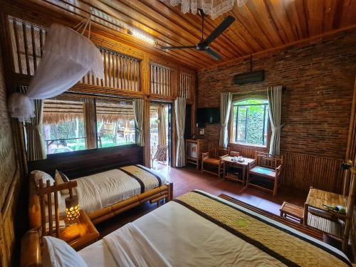 a bedroom with two beds in a room with wooden ceilings at Bamboo Eco Village in Can Tho