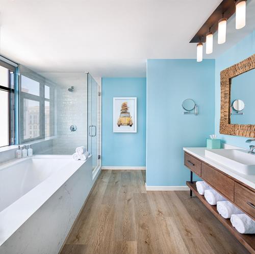 a bathroom with a large tub and a sink at Margaritaville Hotel San Diego Gaslamp Quarter in San Diego