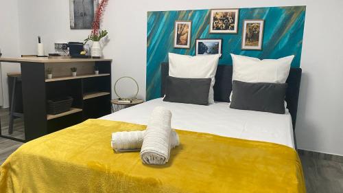 une chambre avec un grand lit avec une couverture jaune dans l'établissement L'ATELIEr COSY, à Cayenne