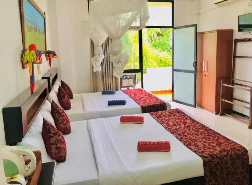 a bedroom with two beds and a window at Awon Mirissa in Mirissa