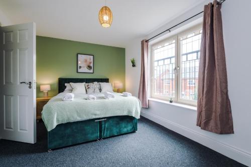 a bedroom with a bed and a large window at Lovely 4 Bed/ Monthly Discount/ Bottle in Litherland