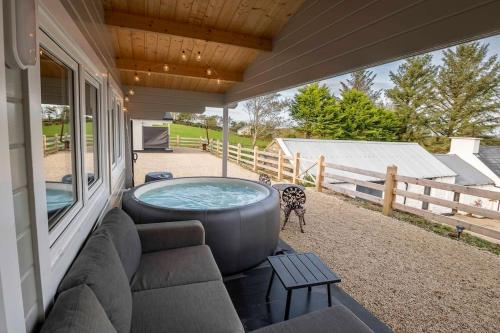 a hot tub sitting on the side of a house at Luxury Log Cabin with Private Hot Tub & Sea Views in Letterkenny