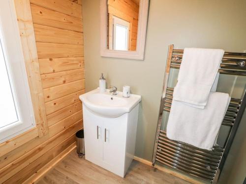 y baño con lavamanos y toallero. en Luxury Log Cabin with Private Hot Tub & Sea Views, en Letterkenny