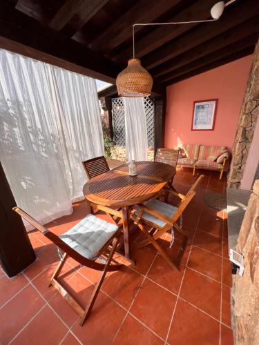 comedor con mesa de madera y sillas en Villetta la Cinta, en San Teodoro