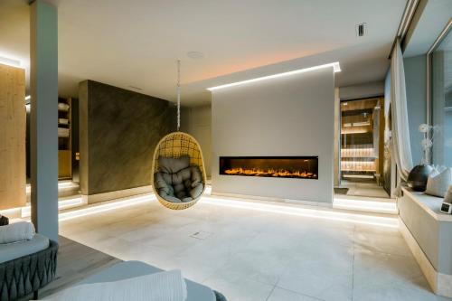a living room with a fireplace and a hanging chair at AlpinSpa zur Post Apartment - Bergbahn im Sommer 2025 inklusive in Bad Gastein