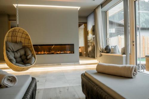 a living room with a hanging chair and a fireplace at Appartementhaus zur Post in Bad Gastein