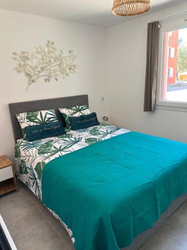 une chambre avec un grand lit avec une couette bleue dans l'établissement Résidence les Hameaux de Saint Cyprien appartement LUNA 132, à Lecci