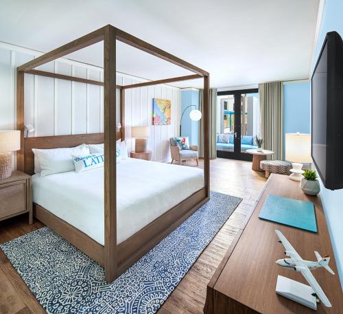 a bedroom with a canopy bed and a living room at Margaritaville Hotel San Diego Gaslamp Quarter in San Diego