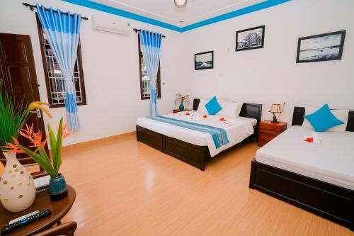 a hotel room with two beds and a table at Tra Que Green Villa Hoi An in Hoi An