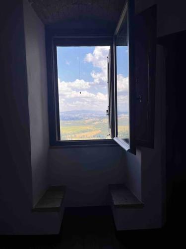 an empty room with a large window with a view at Medieval Tower in Umbria with Swimming Pool in Monte lʼAgello