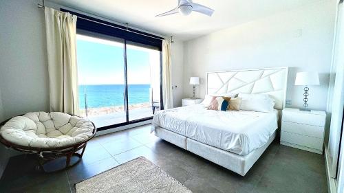 - une chambre avec un lit et une grande fenêtre donnant sur l'océan dans l'établissement Luxurious penthouse duplex with the best sea views, à Manilva