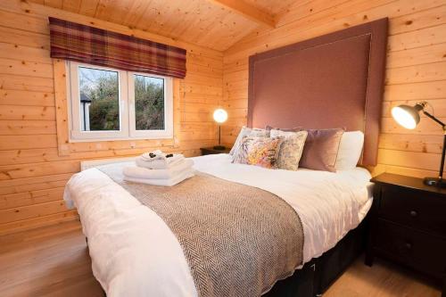 1 dormitorio con 1 cama grande en una cabaña de madera en Luxury Log Cabin with Private Hot Tub & Sea Views, en Letterkenny