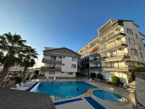 een groot appartementencomplex met een zwembad naast een gebouw bij Apartment in der Nähe vom Strand in Didim