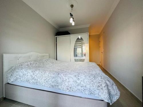 een slaapkamer met een bed met een wit dekbed bij Apartment in der Nähe vom Strand in Didim