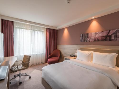 a hotel room with a bed and a desk at Hampton By Hilton Frankfurt City Centre East in Frankfurt