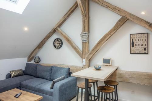 un salon avec un canapé bleu et une table dans l'établissement Maison/appartement avec jardin, à Saint-Denis-en-Val