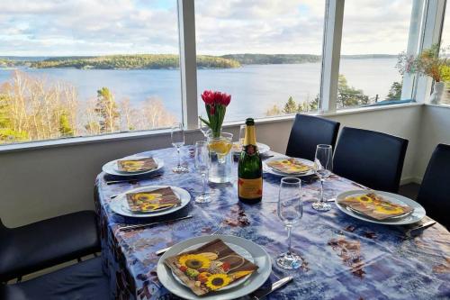 una mesa con platos de comida y una botella de vino en Villa Stockholms skärgård 30 min från Stockholm centralt, en Tyresö