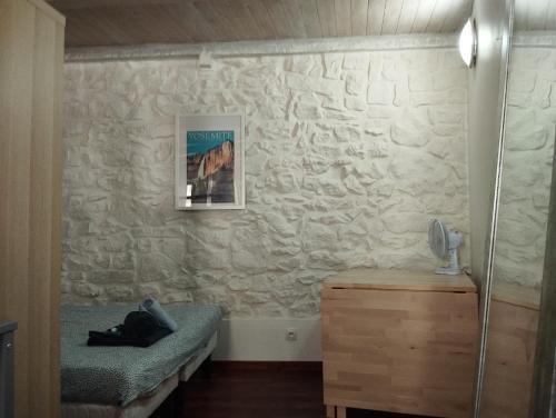 une chambre avec un lit et un mur en pierre dans l'établissement Studio - hypercentre - WIFI et Clim, à Toulon