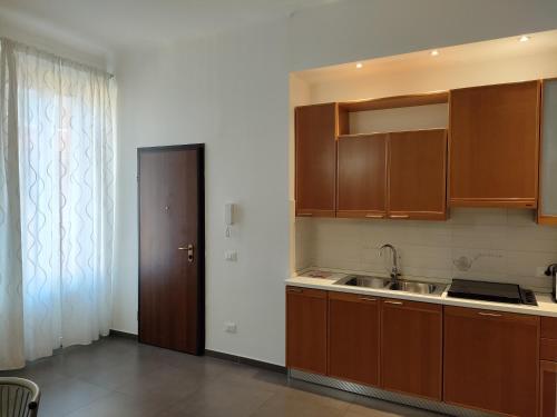 una cocina con armarios de madera y fregadero en B&B Intero Appartamento Forum e Metro Milanofiori, en Assago