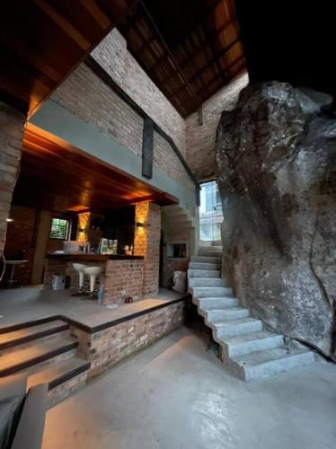 a room with stairs and a large rock at Casa da Pedra Serrinha in Resende
